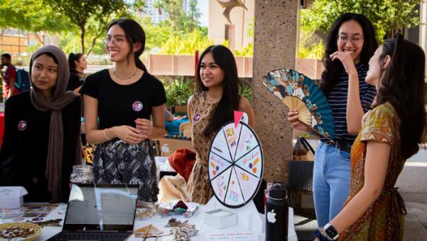 Students gathered around an event table